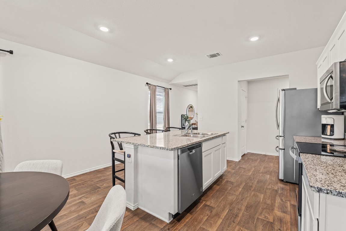 11817 Rush Lane Elgin, TX 78621 - Photo 8 of 30 a kitchen with stainless steel appliances granite countertop a sink stove and refrigerator
