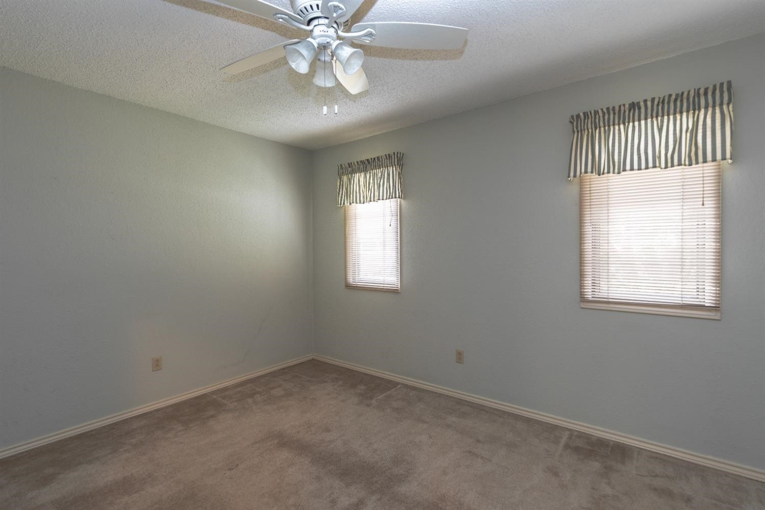 4424 76th Street Lubbock, TX 79424 - Photo 17 of 27 an empty room with windows and fan