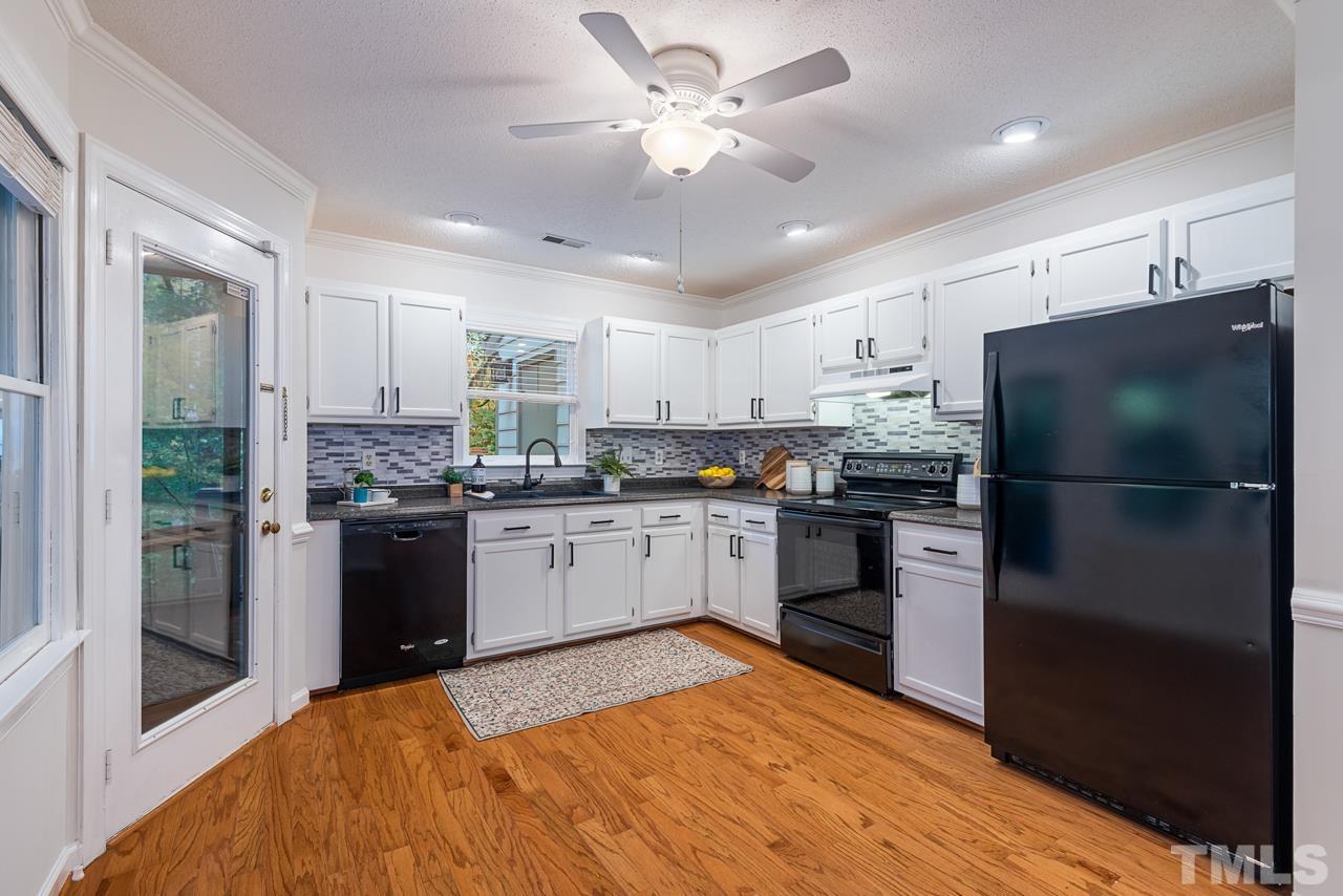 4109 Settlement Drive Durham, NC 27713 - Photo 11 of 31 a kitchen with a refrigerator a sink and cabinets