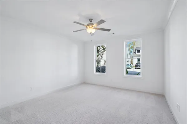 an empty room with windows and fan