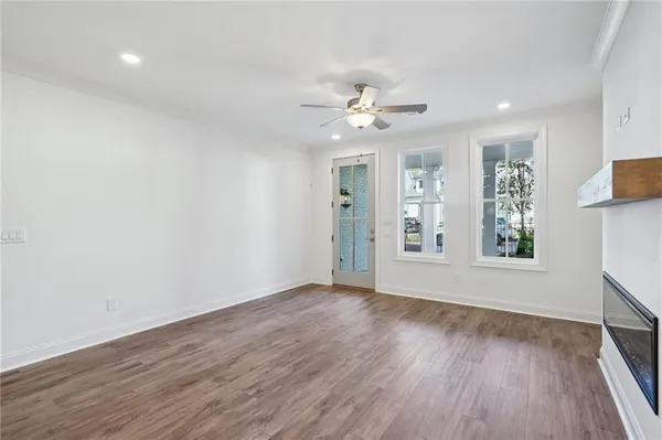 a view of an empty room with a window and wooden floor