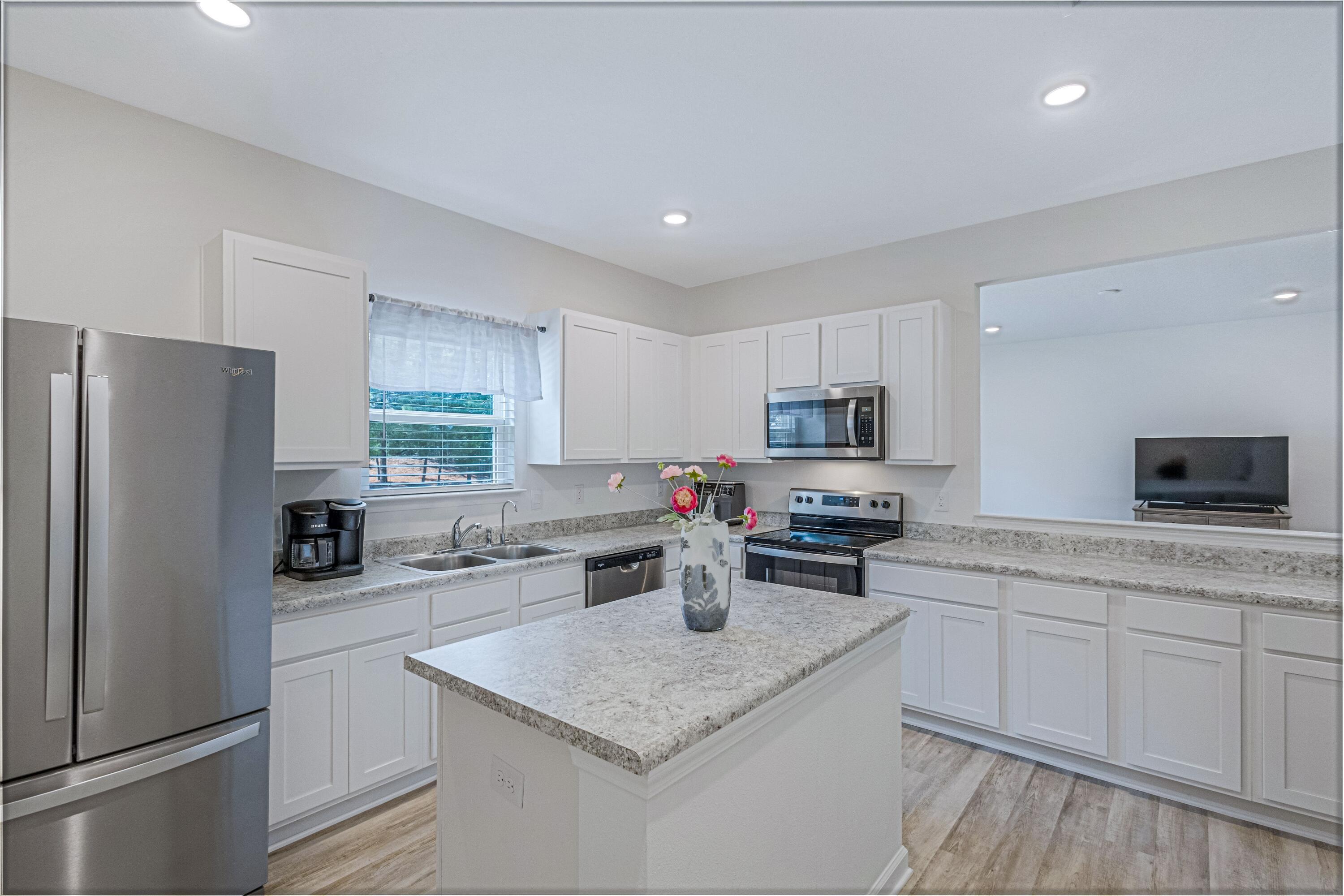 16 Woodsorrel Street Freeport, FL 32439 - Photo 7 of 23 a kitchen with a sink a stove a refrigerator a center island and a window