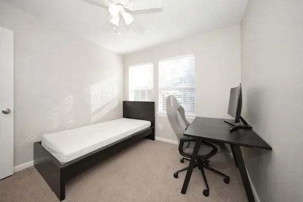 a view of a workspace with furniture and a window