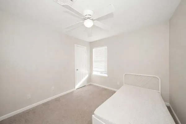 a bedroom with a white bed and a ceiling fan