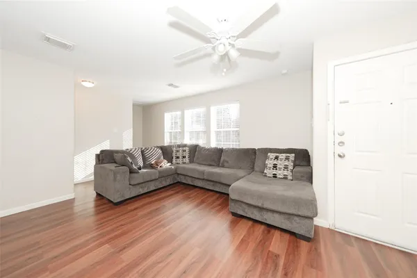a living room with furniture and a wooden floor