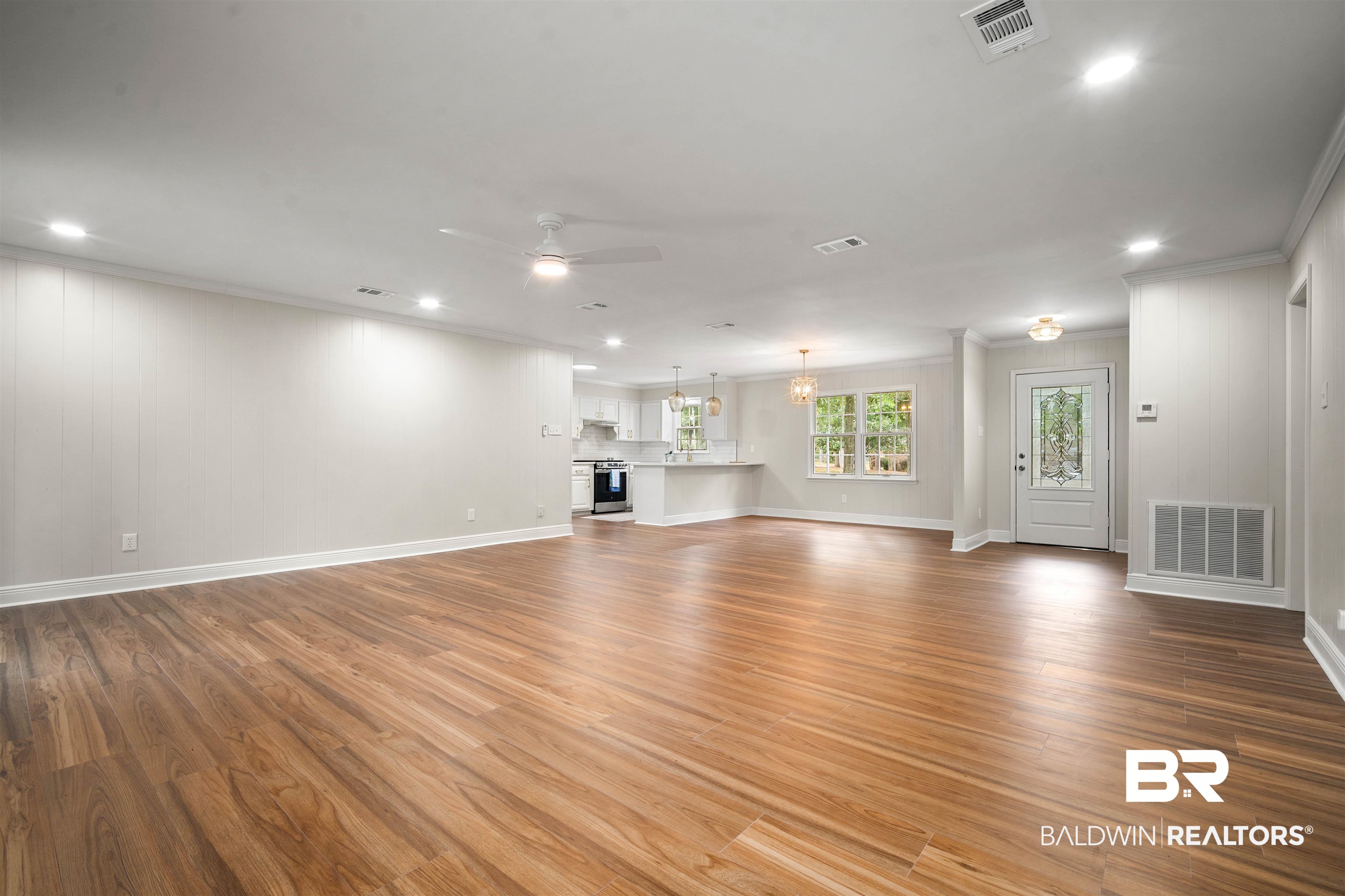 3050 Lacoste Road Mobile, AL 36618 - Photo 5 of 30 Unfurnished living room with light wood-type flooring, crown molding, recessed lighting, a ceiling fan, and a chandelier