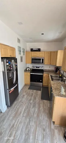 a kitchen with stainless steel appliances granite countertop a stove a sink and a refrigerator