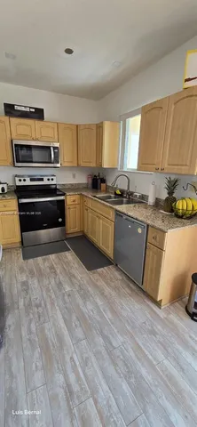 a kitchen with stainless steel appliances granite countertop a stove a sink and a refrigerator