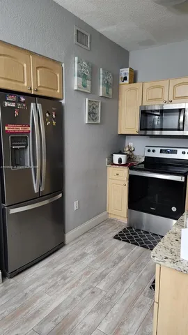 a kitchen with stainless steel appliances granite countertop a stove a refrigerator and a microwave