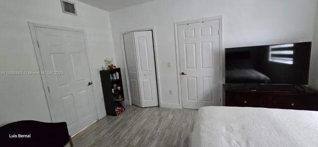 a bedroom with a bed and a flat tv screen