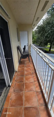 a view of a door and an empty room with a mirror
