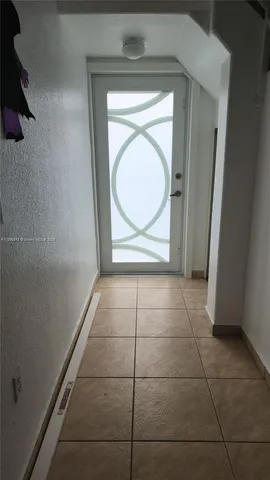 a view of a door and an empty room with a window