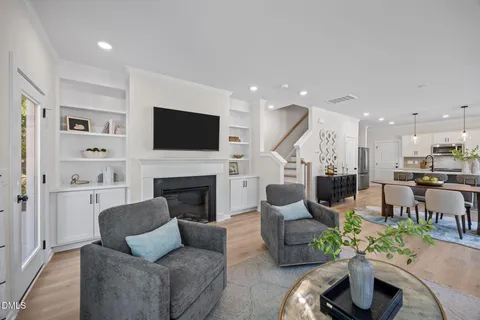 a kitchen with stainless steel appliances a dining table chairs stove refrigerator and cabinets