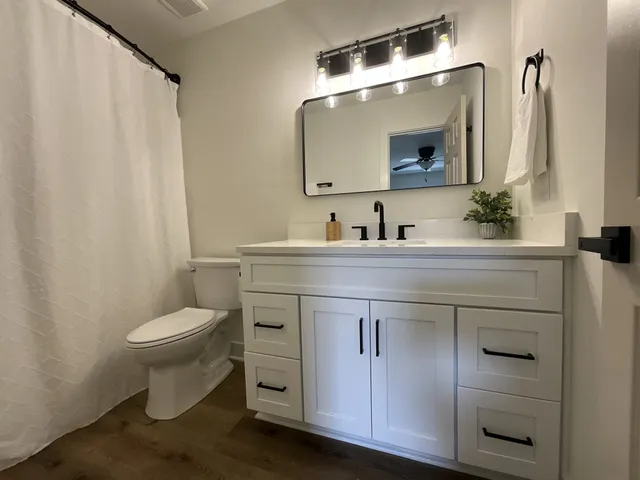 a bathroom with a toilet sink and mirror