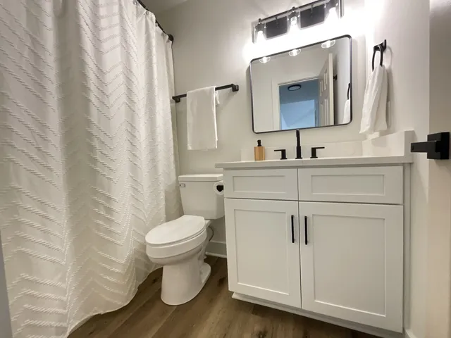 a bathroom with a toilet sink and mirror