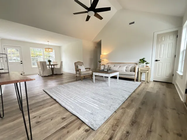 a living room with furniture and a wooden floor