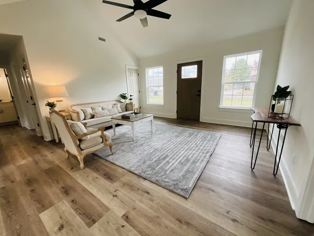 a living room with furniture and a wooden floor