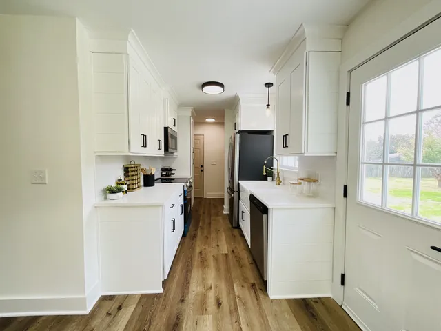 a kitchen with white cabinets and white appliances