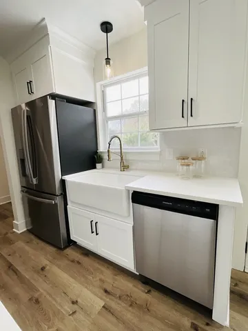 a kitchen with kitchen island a counter space a sink and a refrigerator