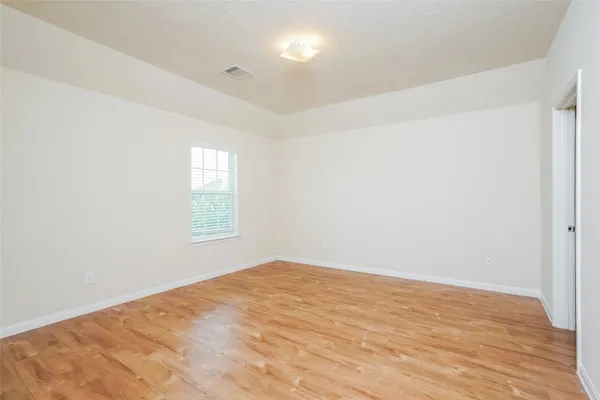a view of empty room with wooden floor