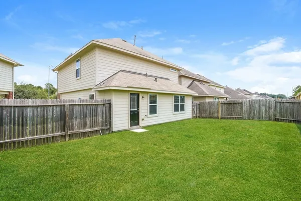a view of a house with a yard and sitting area