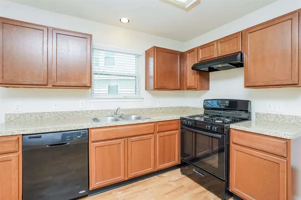 a kitchen with stainless steel appliances granite countertop a stove top oven a sink and dishwasher