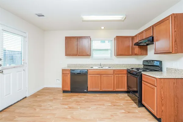 a view of empty room with wooden floor and windows