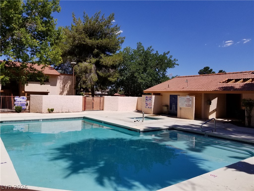 1515 East Reno Avenue, Unit A103 Las Vegas, NV 89119 - Photo 3 of 16 Relax and refresh in this inviting community pool area, complete with an adjacent building and mature landscaping.