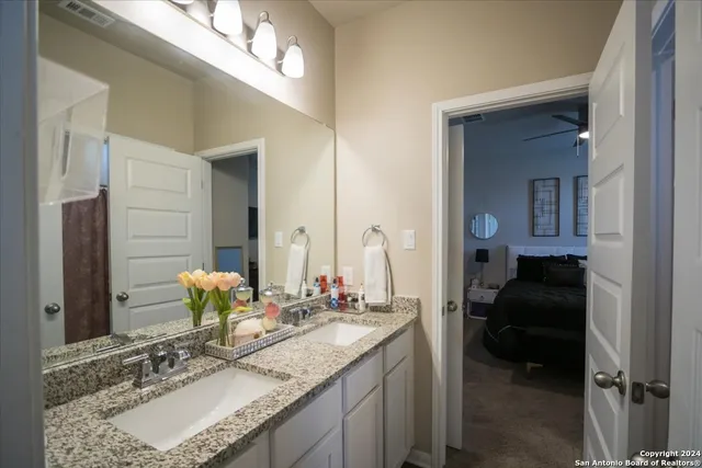 a bathroom with a granite countertop sink and a mirror