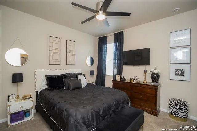 a bedroom with a bed and a flat tv screen on dresser