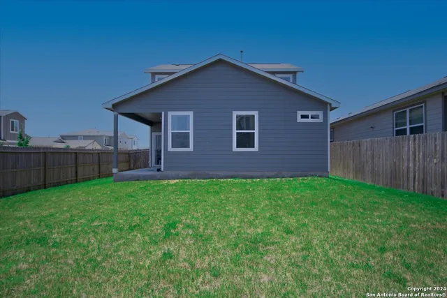 a view of a backyard with wooden fence
