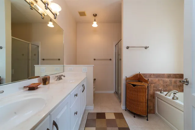 a bathroom with a double vanity sink a toilet and a mirror