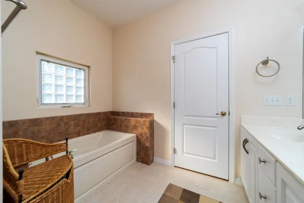 a bathroom with a tub sink and mirror