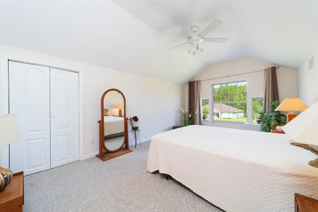 a bedroom with a bed and a large window
