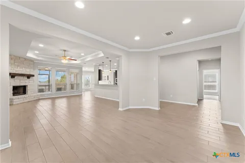 a view of an empty room with window and wooden floor