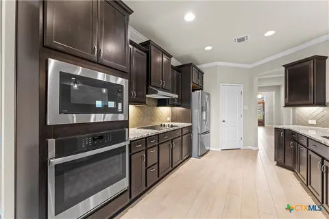 a kitchen with stainless steel appliances granite countertop a stove and a microwave