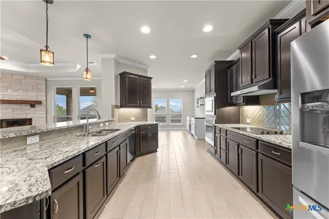 a large kitchen with stainless steel appliances granite countertop a lot of counter space and wooden floor