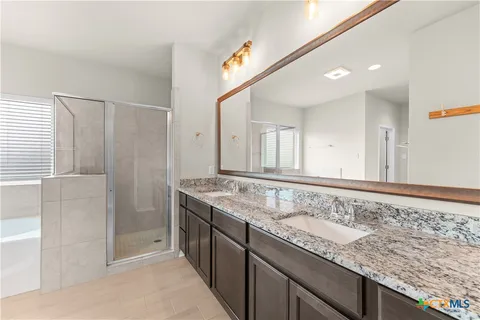a bathroom with a granite countertop sink and a mirror