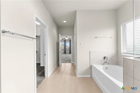 a bathroom with a tub shower and window