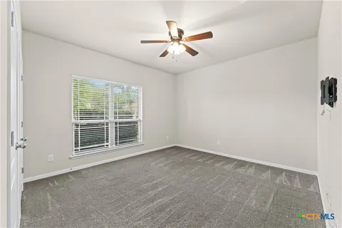 an empty room with windows and fan