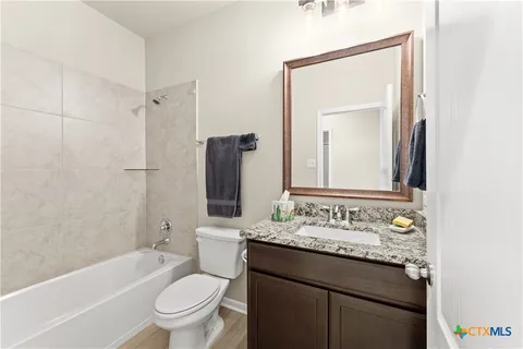 a bathroom with a granite countertop sink toilet and shower