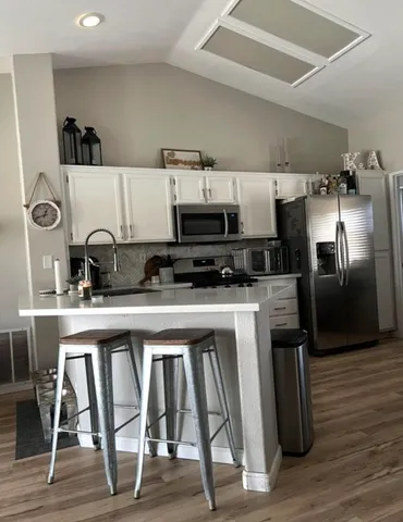 a kitchen with stainless steel appliances a refrigerator and a stove top oven