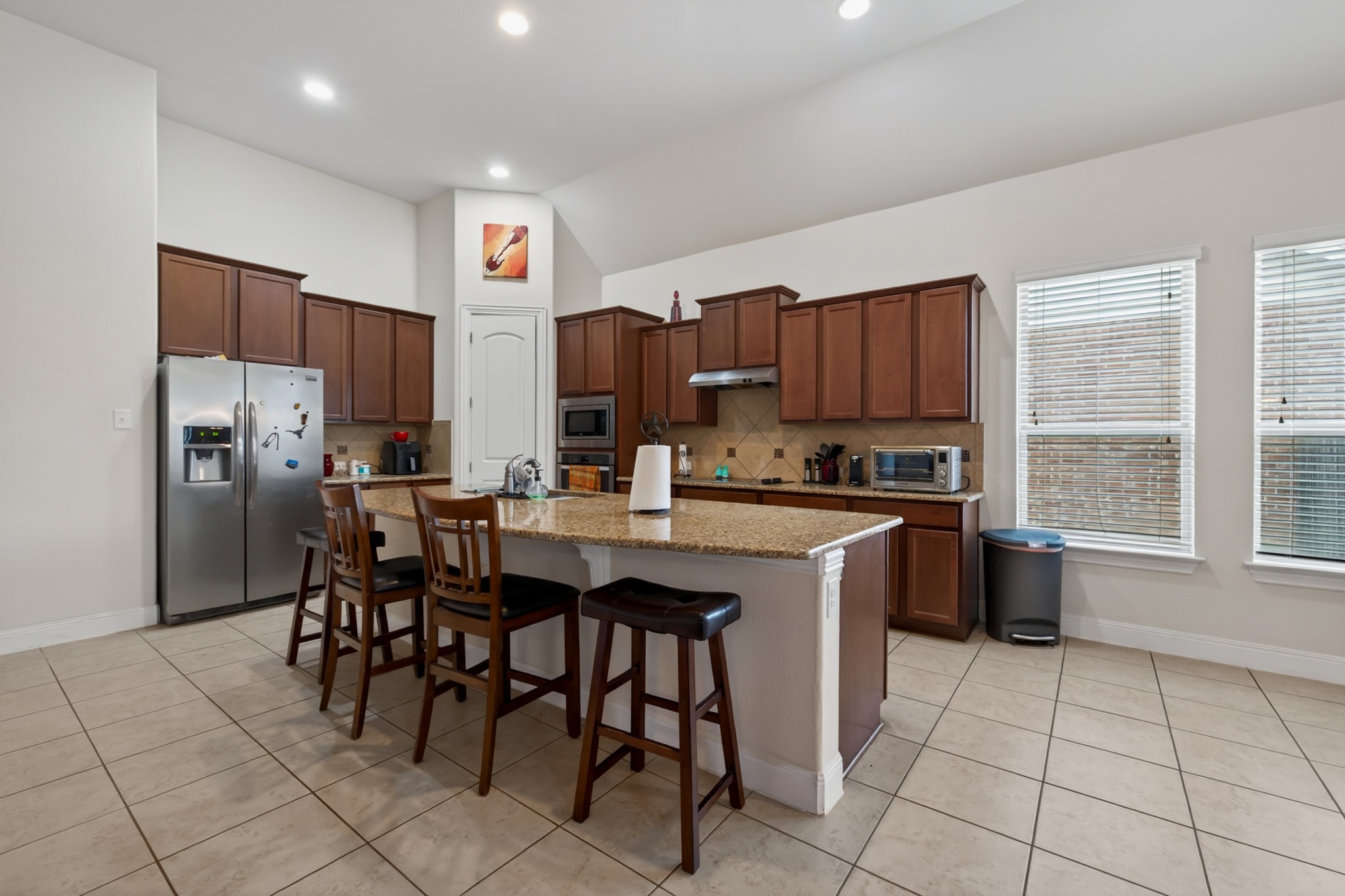 1017 Tabernash Leander, TX 78641 - Photo 8 of 38 Kitchen featuring an expansive center island with a granite-style countertop, integrated sink, and seating for four