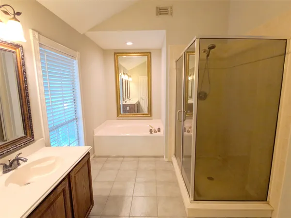 a bathroom with a tub sink and mirror