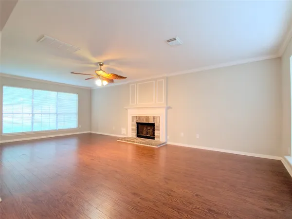 a view of empty room with wooden floor and fireplace