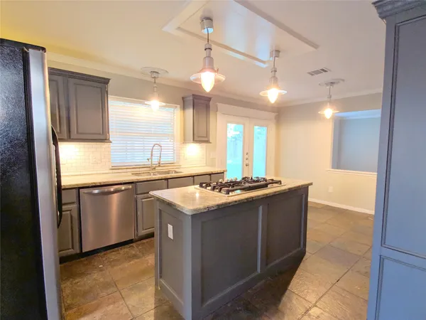 a kitchen with stainless steel appliances granite countertop a stove a sink and a refrigerator