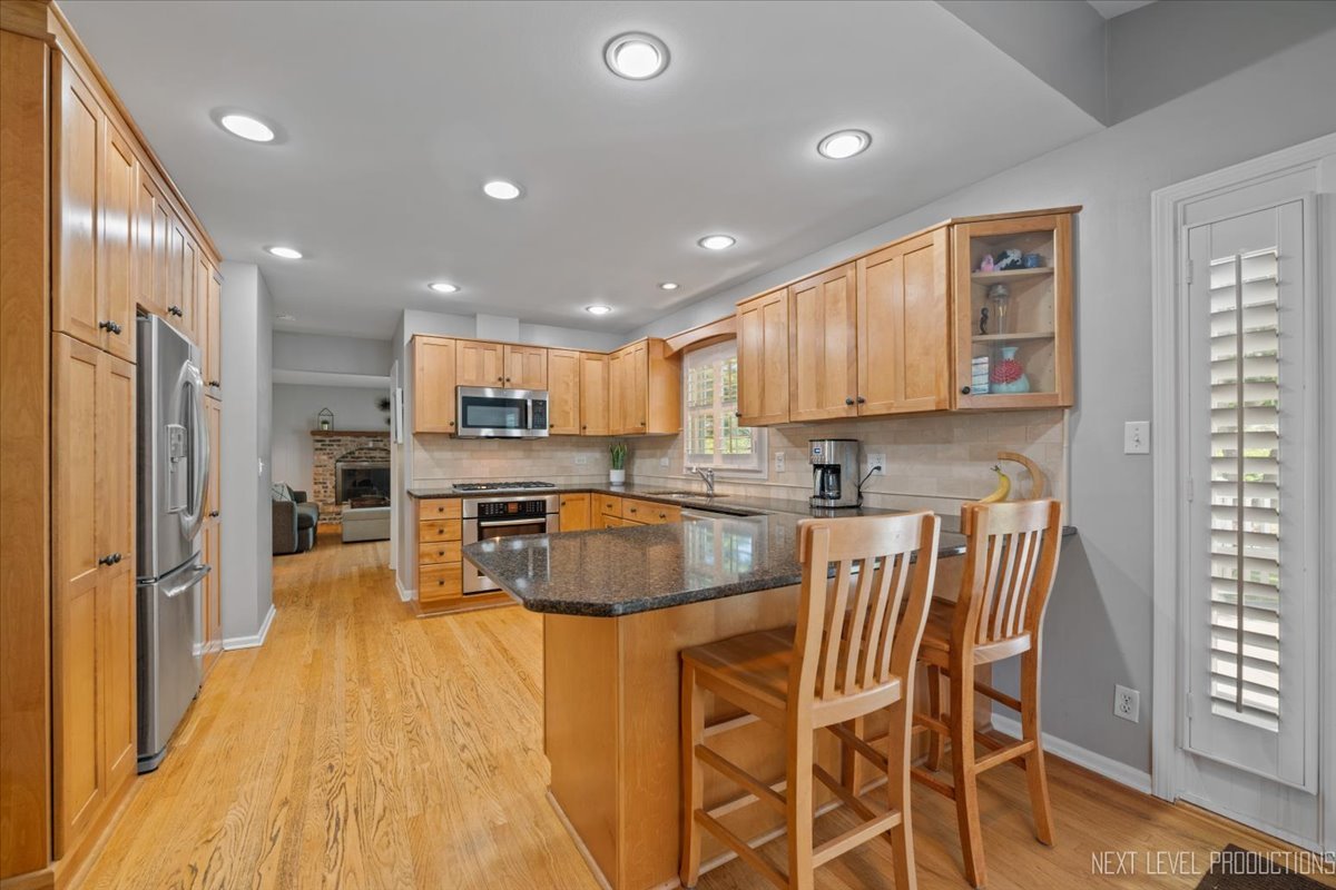 1009 East Bailey Road Naperville, IL 60565 - Photo 8 of 33 a kitchen with stainless steel appliances granite countertop a refrigerator and a stove top oven