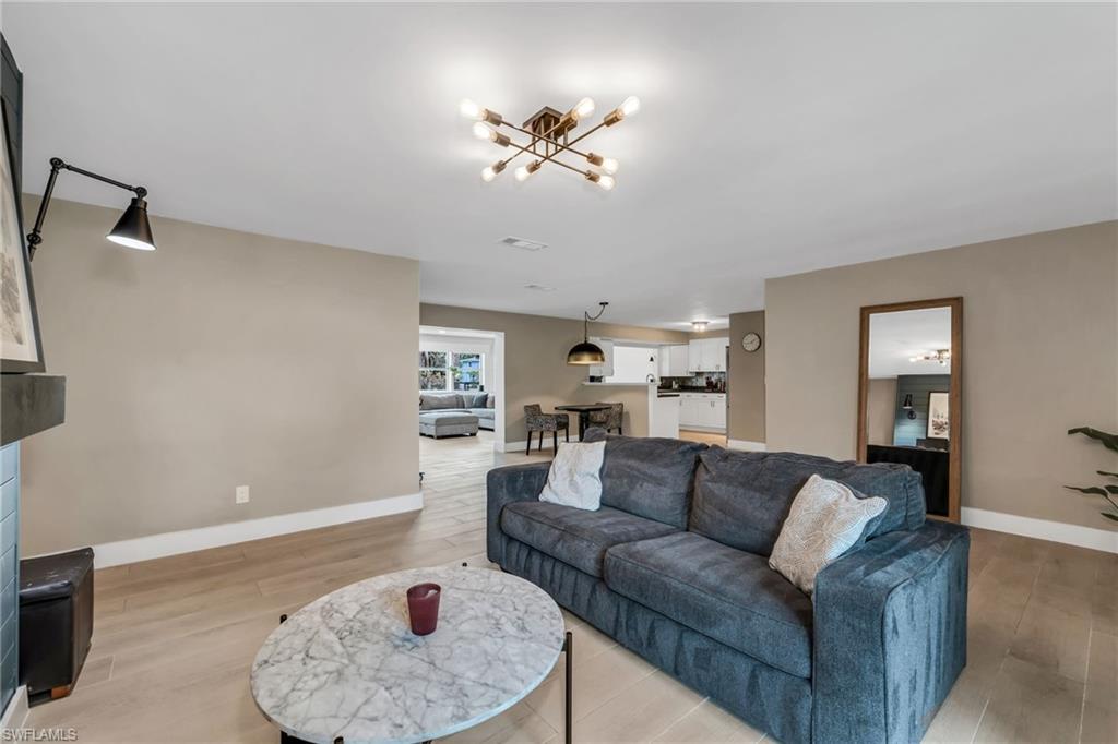1840 23rd Street Southwest Naples, FL 34117 - Photo 11 of 50 Family room featuring light wood plank porcelain tile flooring and a fireplace