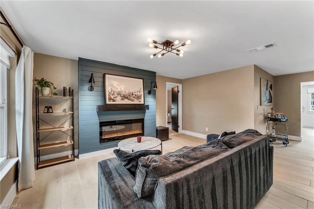 1840 23rd Street Southwest Naples, FL 34117 - Photo 12 of 50 Family room featuring light wood plank porcelain tile flooring and a fireplace