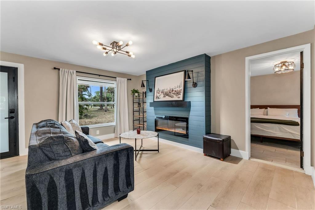 1840 23rd Street Southwest Naples, FL 34117 - Photo 13 of 50 Family room featuring light wood plank porcelain tile flooring and a fireplace